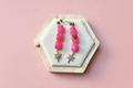 Boucles d'oreilles dorées — fond rose poudré