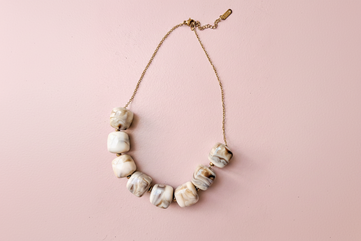 Collier perles marbrées — fond rose poudré